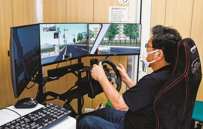 「運転シミュレーター」を体験する地域交通安全活動推進委員=米子市上福原、米子署