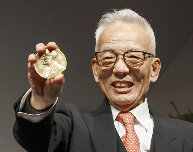 ノーベル物理学賞のメダルを手に笑顔を見せる真鍋淑郎・米プリンストン大上席研究員＝２０２１年１２月６日、米ワシントンの科学アカデミー（共同）