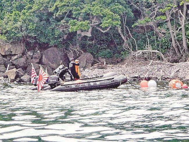 魚雷とみられる物体を潜水調査する海上自衛隊舞鶴地方隊の水中処分員＝１０日午後（読者提供、安全な距離から望遠レンズで撮影）