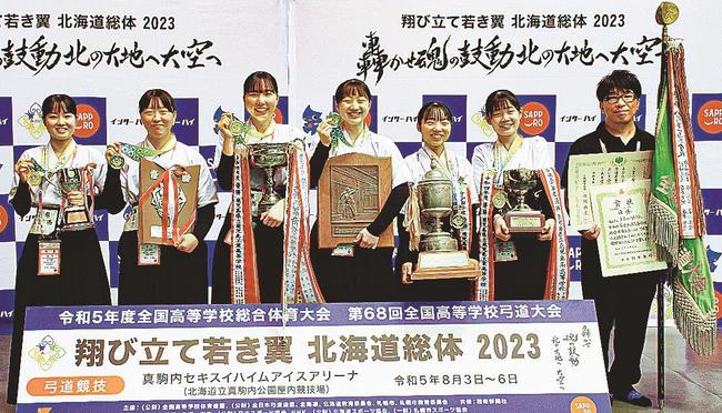 北海道総体の弓道女子団体で優勝した倉吉西の（左から）有沢侑楽、酒井心優、西村有花、森脇心、生田愛澄、筏津凜、福光善太監督＝札幌市、真駒内セキスイハイムアイスアリーナ