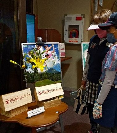 「山陰ご縁むす美レディース」の特製ティーマークに見入る女性ゴルファー＝鳥取県伯耆町丸山、大山平原ゴルフクラブ