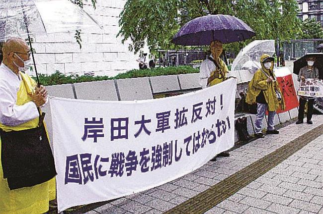 防衛費増額の財源を確保するための特別措置法案に反対し、国会前に集まった市民ら。特別措置法は今国会で成立した=5月19日