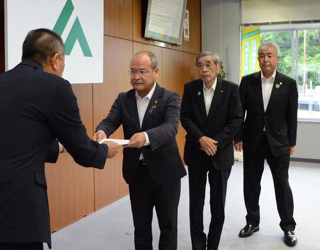 ＪＡしまね雲南地区本部の佐藤善雄副本部長（左）に和牛肥育事業継続の要請書を手渡す石飛厚志雲南市長（左から２人目）ら＝７月１５日、同市木次町里方