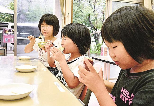口いっぱいに焼き芋スティック付きのジェラートを?張る児童＝浜田市三隅町向野田、聖?寮
