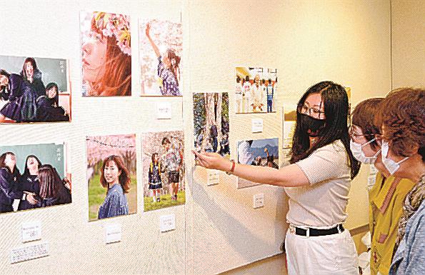 写真を来場者に説明する森陽子さん（左）＝境港市花町、海とくらしの史料館