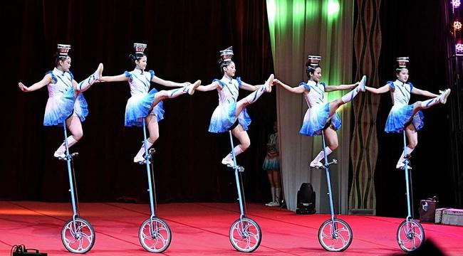おわんを頭にのせ、息の合った曲芸を披露する演者たち＝松江市学園南１丁目、旧島根県立プール跡地特設大テント