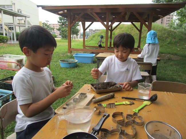 泥遊びを楽しむ島根大付属幼稚園の園児たち。後方が「どろんこハウス」＝松江市大輪町