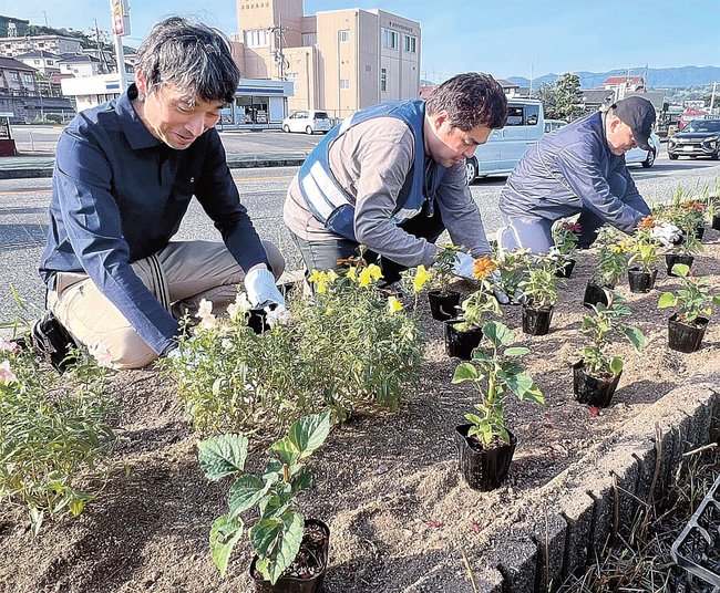花壇に花の苗を植える会員たち＝浜田市笠柄町