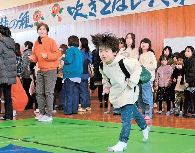 勢いよく柿の種を飛ばすジュニアの部の参加者＝鳥取県南部町天萬、町農業者トレーニングセンター