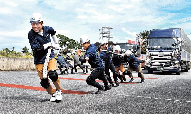 懸命にトラックを引っ張る参加者＝江津市江津町、市総合市民センター駐車場