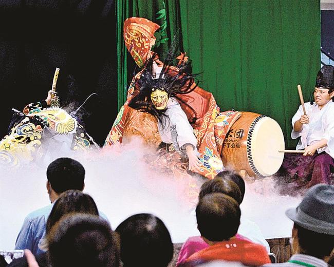 迫力いっぱいに「葛城山」を演じる都神楽団の団員＝広島市南区、広島駅南口エールエール地下広場
