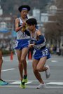 平田の６区冨岡成望（左）からたすきを受け、走り出す７区加藤蒼梧＝西大路下立売、第６中継所 
