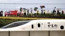 旗や横断幕を手に、西九州新幹線開業を歓迎する人たち＝２３日、長崎県大村市