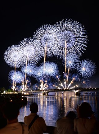 宍道湖上４カ所から一斉に打ち上げられ、夜空を焦がす大輪の花火＝５日午後８時４３分、松江市・松江大橋（長時間露光）