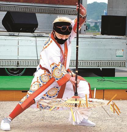 傘を下に向け、すくうような所作を取り入れて踊る小西利雄さん＝安来市中海町、道の駅あらエッサ