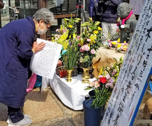 「のんのんばあとオレ」のブロンズ像前で手を合わせる参拝者＝出雲市小境町、一畑薬師