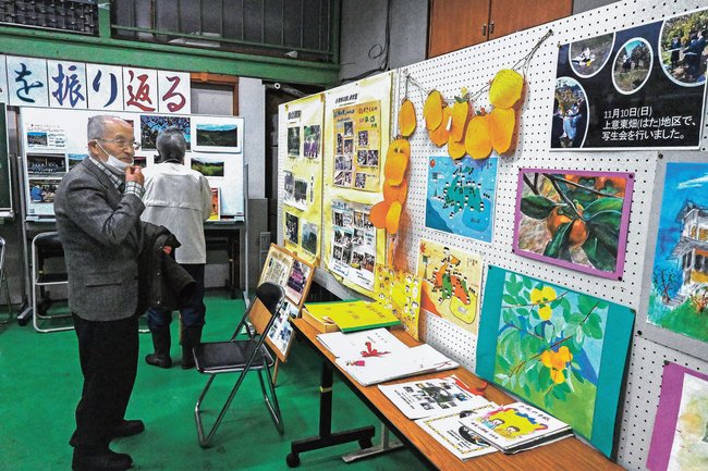 畑地区での干し柿の歴史を紹介する資料を見る参加者=松江市東出雲町上意東、畑公会堂