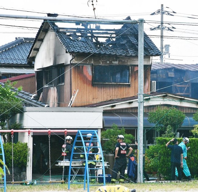焼けた民家を調べる消防隊員ら＝１３日午後１時５０分、鳥取市古海
