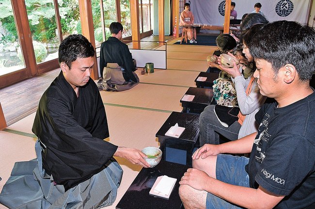 抹茶のもてなしを受ける来場者（右）＝益田市東町、万福寺