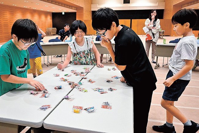 為替レートを確認しながら商品を仕入れる輸入体験ゲームを楽しむ参加者＝松江市魚町、山陰合同銀行本店