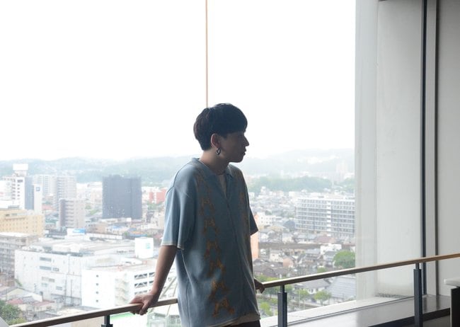 故郷・松江の町並みを見渡せる展望フロアで撮影に挑む石原慎也さん＝松江市魚町、山陰合同銀行本社展望フロア