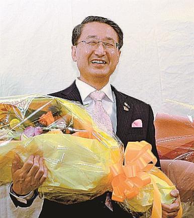 （８）５選を確実にし、花束を手にして喜ぶ平井伸治氏＝４月９日、鳥取市内