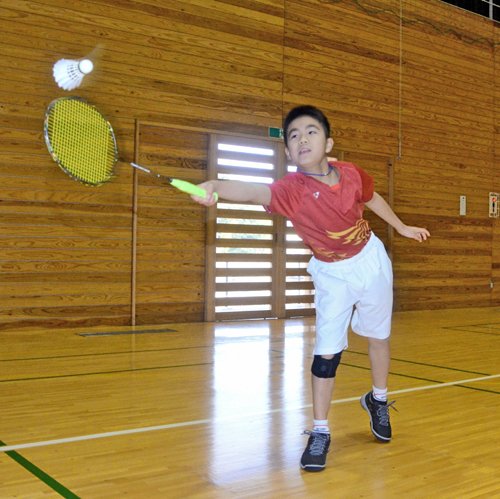懸命にシャトルに食らいつく加本逸真君＝出雲市上塩冶町、上塩冶スポーツセンター