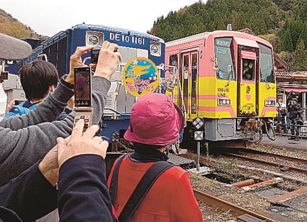 出雲坂根駅で「奥出雲おろち号」（左）の到着を待って出発する普通列車＝１１日、島根県奥出雲町八川
