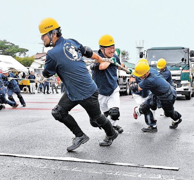懸命にトラックを引っ張る参加者＝江津市江津町、市総合市民センター