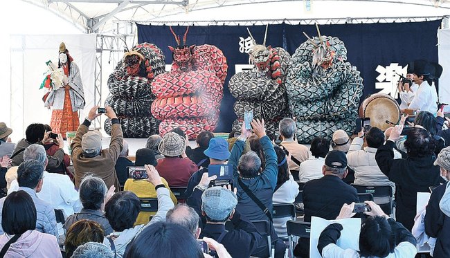 石見神楽を鑑賞する三井オーシャンフジの乗客ら=浜田市原井町、はまだお魚市場