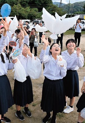 平和の象徴・ハトの形の白いバルーンを飛ばす参加者＝安来市広瀬町布部
