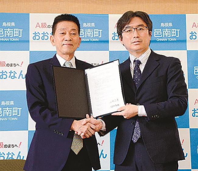 協定書に調印後、握手を交わす石橋良治町長（左）と土志田敬祐社長＝島根県邑南町矢上、邑南町役場