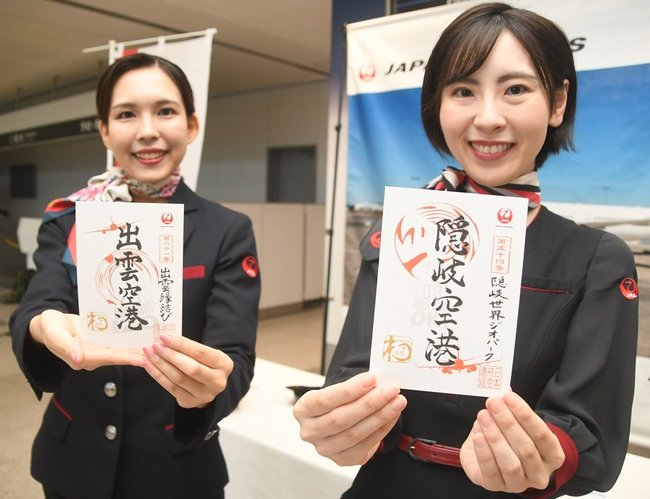 隠岐、出雲両空港の御翔印をＰＲする伊藤萌花さん（左）ら携わったメンバー＝出雲市斐川町沖洲、出雲空港