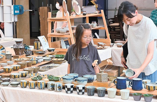器を手に取って品定めする来場者＝松江市殿町、カラコロ工房