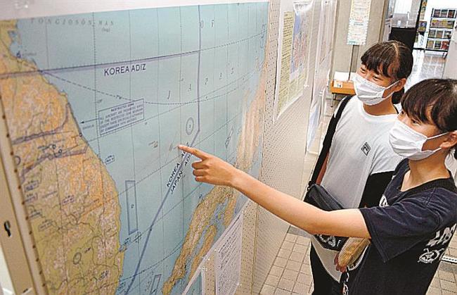 米空軍航空図の複製で竹島の境界を確認する来庁者＝浜田市殿町、市役所