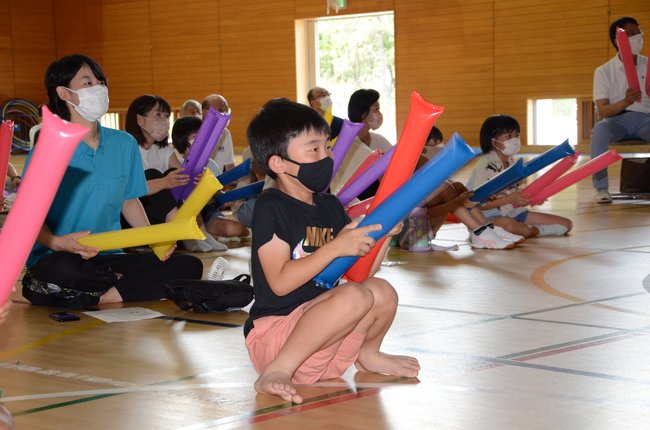 風船をたたいて三浦龍司選手を応援する子どもたち＝浜田市下府町、国府小学校
