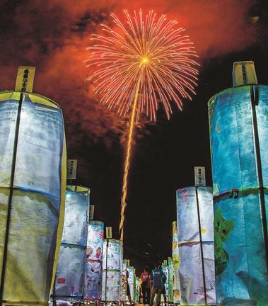 手づくりの灯籠が並ぶ会場で、花火を楽しむ来場者＝島根県邑南町山田