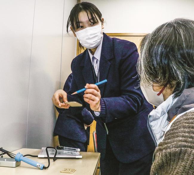 木製マグネットの作り方を伝える生徒（左）＝松江市西浜佐陀町、古江公民館