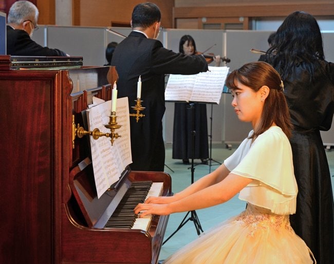 弦楽に合わせてノヴィーを演奏する安達優衣さん＝松江市玉湯町大谷、旧大谷小学校