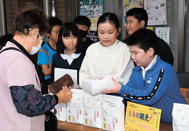 田植えから収穫までした米を販売する児童ら＝島根県奥出雲町三成、仁多特産市