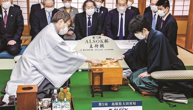 対局開始前に駒を並べる羽生善治九段（左）と藤井聡太王将（提供：日本将棋連盟）