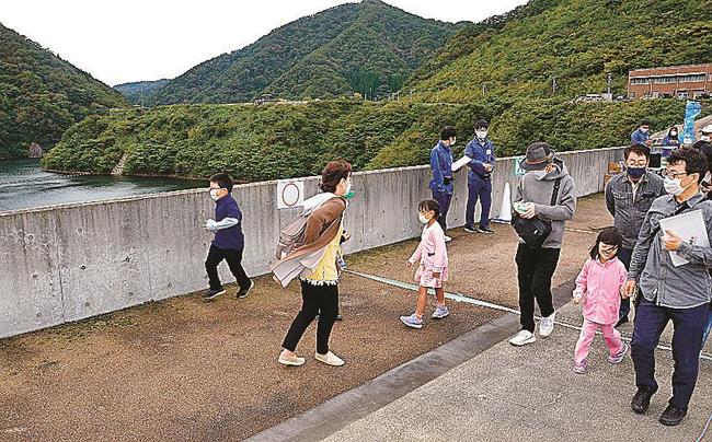 志津見ダム天端でクイズに挑戦する参加者＝島根県飯南町角井
