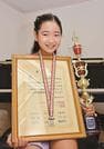 コンクールの賞状とメダル、トロフィーを披露する佐々木実紅さん＝松江市内