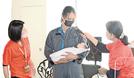 首が据わる前の赤ちゃんを模した人形を抱く社員＝松江市西尾町、マツダオートザム松江
