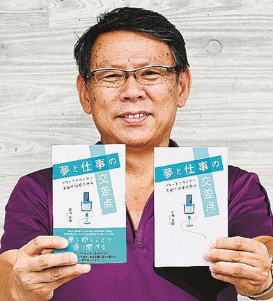 エッセー「夢と仕事の交差点」を手にする庄司正樹さん＝安来市内