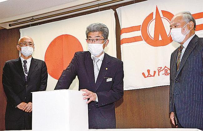 当選者を選ぶ飯野正史取締役＝松江市殿町、山陰中央新報社