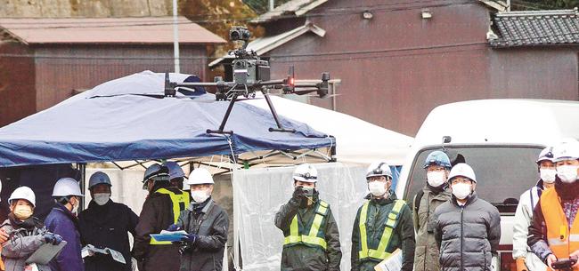 ドローンを見守る関係者=大田市温泉津町湯里