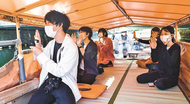 堀川遊覧船に乗船して景色をカメラに収めるスタッフら＝松江市内