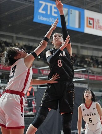 【女子２回戦・鳥取城北―桜花学園】第２クオーター、桜花学園のシュートをディフェンスする鳥取城北のアマルメンド アヌジン（左）＝24日、東京体育館
