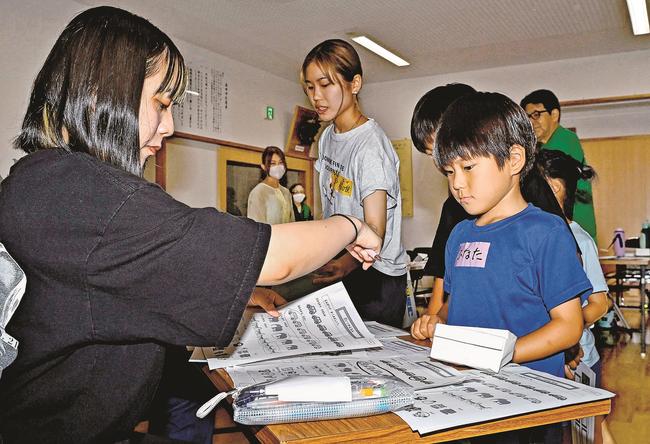 大学生（左）から算数を教わる参加者＝益田市匹見町澄川、匹見下公民館
